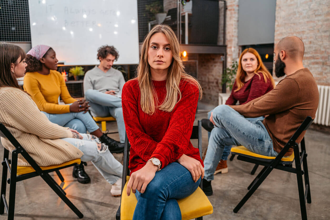 Image of a young woman with social anxiety at a group therapy session.